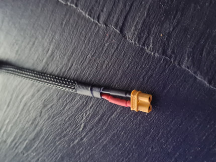 Small electrical cable with connectors on a dark textured surface