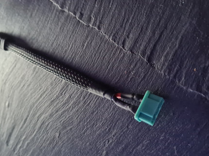 Black cable with a blue connector on a dark textured surface
