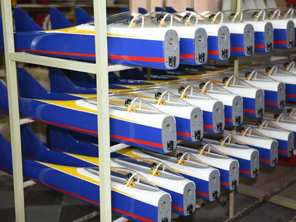 Row of Phoenix Model TYPHOON 59" Size ARF model airplanes with blue, white, and red color scheme on a rack.