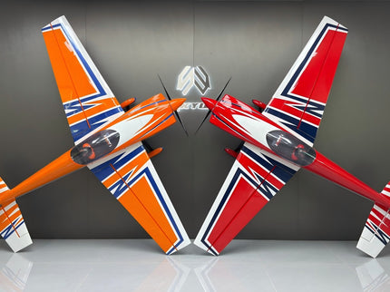 Two model airplanes, one orange and white, the other red and white, on a reflective surface with a dark background.