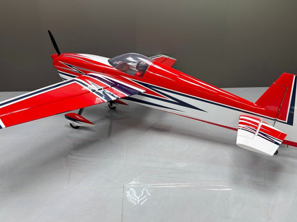 Red and white model airplane on a gray surface with a neutral background