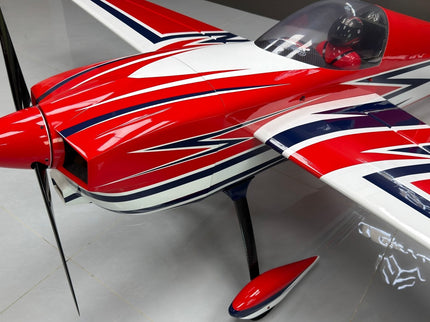 Red and white model airplane with a propeller on a gray floor