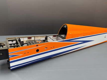 Orange, white, and blue model airplane on a gray surface with a neutral background