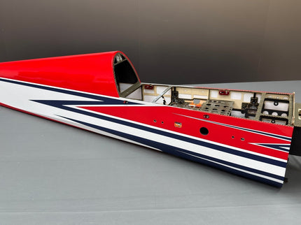 Red, white, and blue model airplane on a gray surface with a blurred background