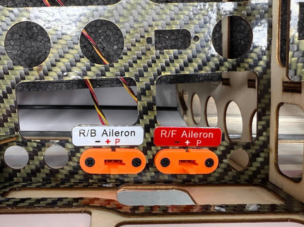 Control panel with aileron switches and labels on a carbon fiber background