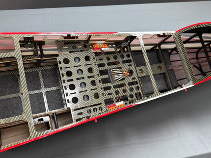 Close-up of a red and black model airplane wing on a gray surface
