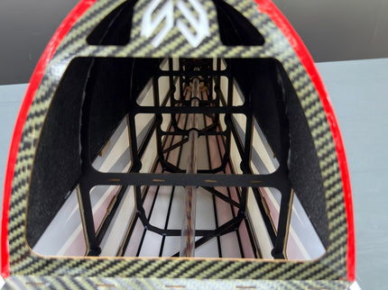 Close-up of fuselage with red and black pattern on a gray surface