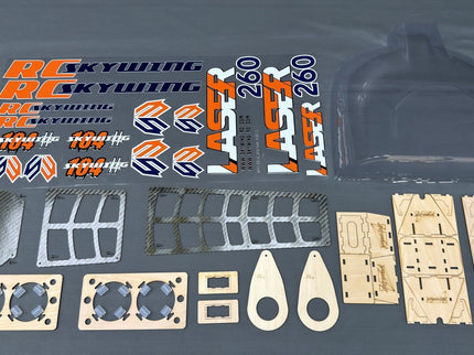 Set of RC plane parts including decals and plastic components on a gray background