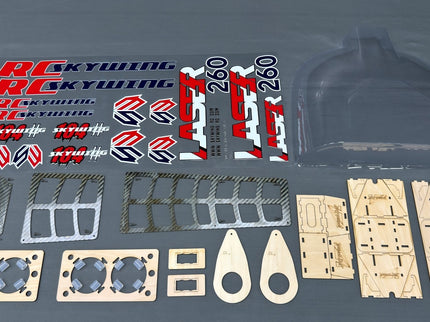 Collection of RC model parts including decals and plastic components on a gray background