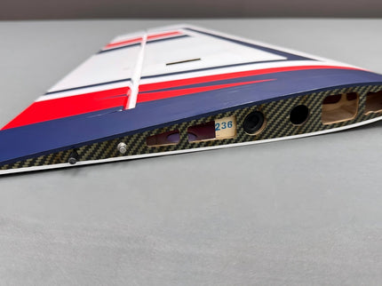 Carbon fiber airplane wing with red and blue stripes on a gray background