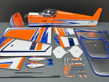Model airplane parts with orange, blue, and white design on a gray surface.