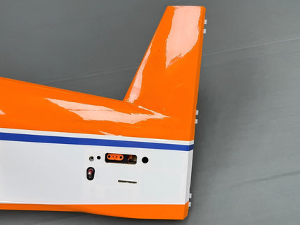 Close-up of an orange and white model airplane on a gray background