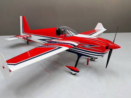 Red and white model airplane on a gray surface with a neutral background