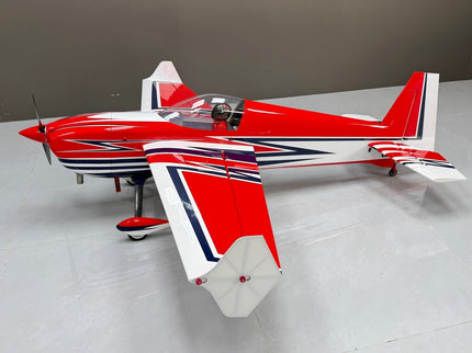 Red and white model airplane with blue accents on a gray surface