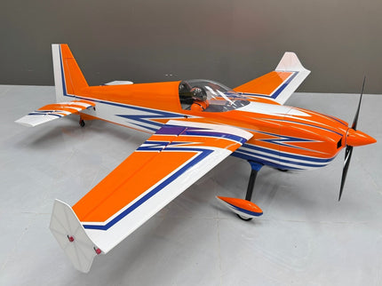 Orange and white model airplane on a gray surface with a neutral background