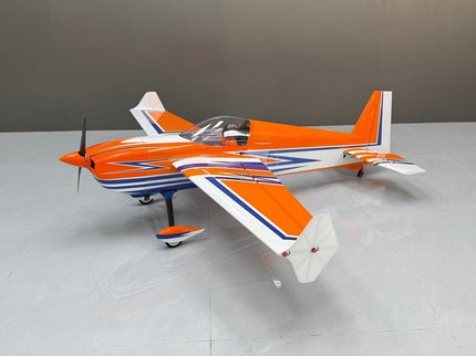Orange and white model airplane on a gray surface with a neutral background