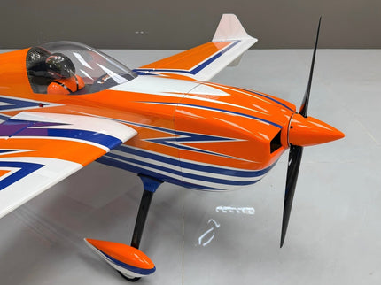 Orange and blue model airplane on a white surface with a gray background