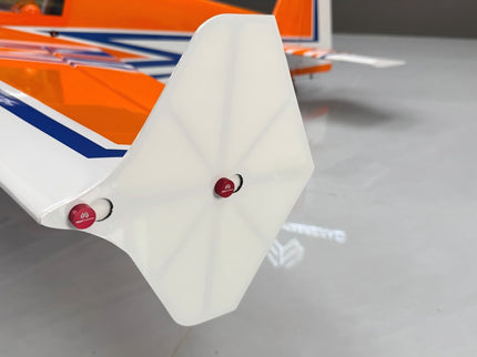 Close-up of a model airplane's wing with red accents on a gray surface