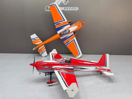 Two model airplanes, one red and white, the other orange and white, on a gray surface with a neutral background.