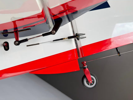 Close-up of a red and white model airplane on a gray background