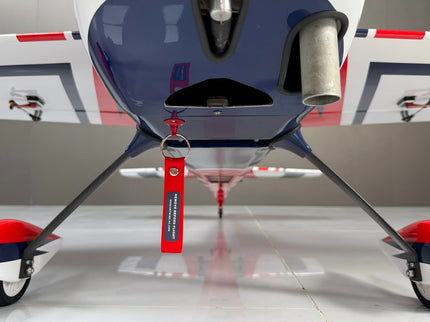 Close-up of a small aircraft with red, white, and blue accents on a gray background