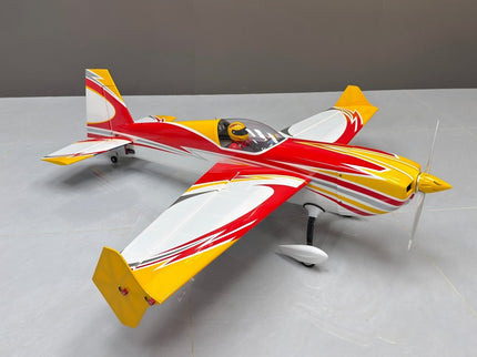 Model airplane with red, yellow, and white colors on a gray surface.