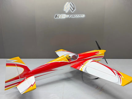 Model airplane with red and yellow design on a gray surface, branded 'Revell' in the background.