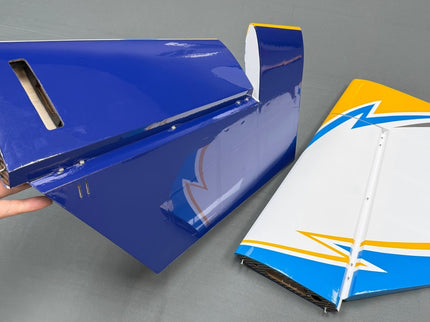 Blue and white model boat hull with sail on a gray background