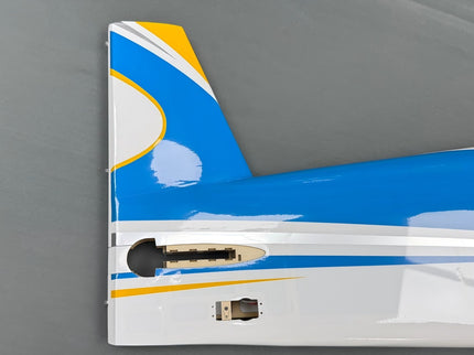 Close-up of a model airplane tail with blue, white, and yellow design on a gray background