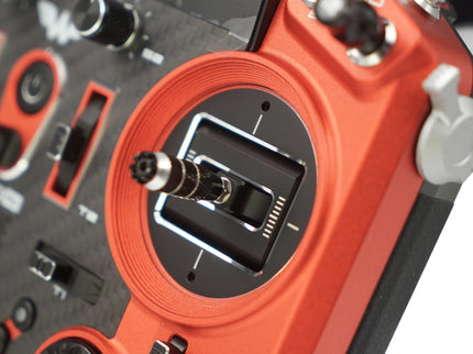 Close-up of a red and black electronic device with various controls and connectors.