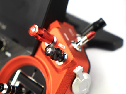 Close-up of a red guitar pedal with multiple knobs on a white background