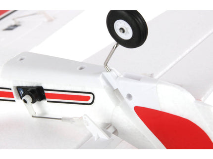 Close-up of a model airplane with red and black details on a white background