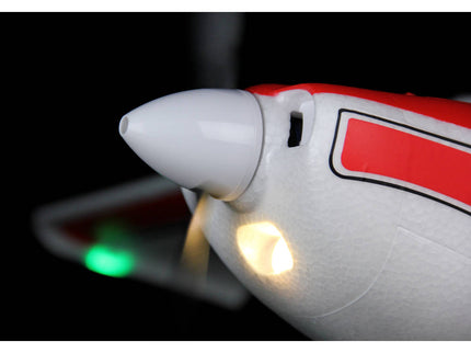 Close-up of a model airplane with glowing lights on a dark background
