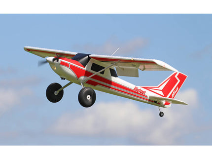 Model airplane flying against a blue sky with clouds