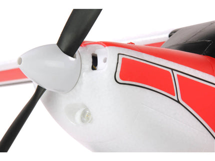 Close-up of a red and white airplane with a black propeller on a white background