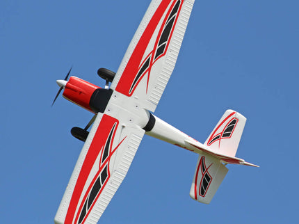 Model airplane with red and black design against a clear blue sky