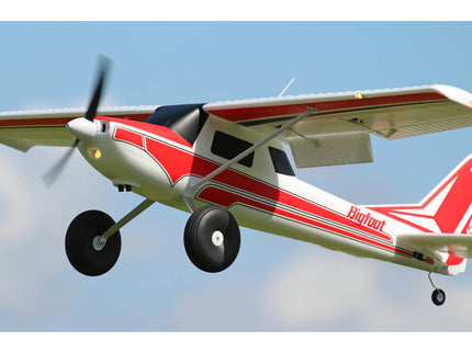 Small red and white airplane with propeller against a clear blue sky