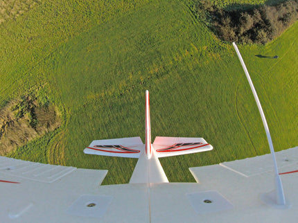 Model airplane on a grassy field with a clear sky