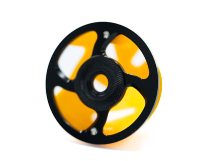 Yellow and black spool of thread on a white background