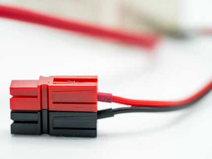 Red and black electrical connector with wires on a white background