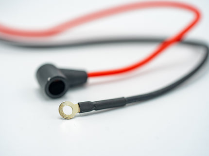 Close-up of a black and red cable with a metallic connector on a white background