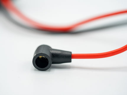 Close-up of a black connector with red cable on a white background