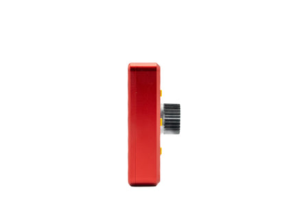 Red electronic device with a black knob on a white background