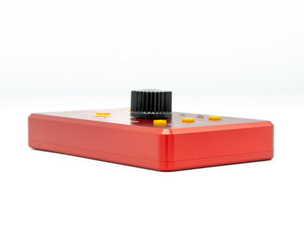 Red electronic device with a black knob on a white background