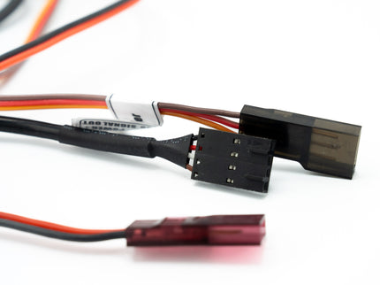 Close-up of electronic connectors with red and black wires on a white background