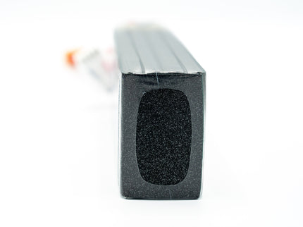 Black rectangular object with textured surface on a white background