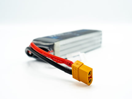 Battery pack with red and black cable and yellow connector on a white background