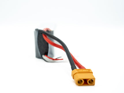 Yellow connector with black and red wires on a white background