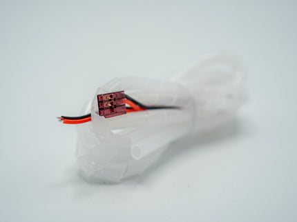 White shoe with a small electronic component on a light gray background