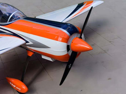 Orange and white model airplane with a black propeller on a tiled floor.